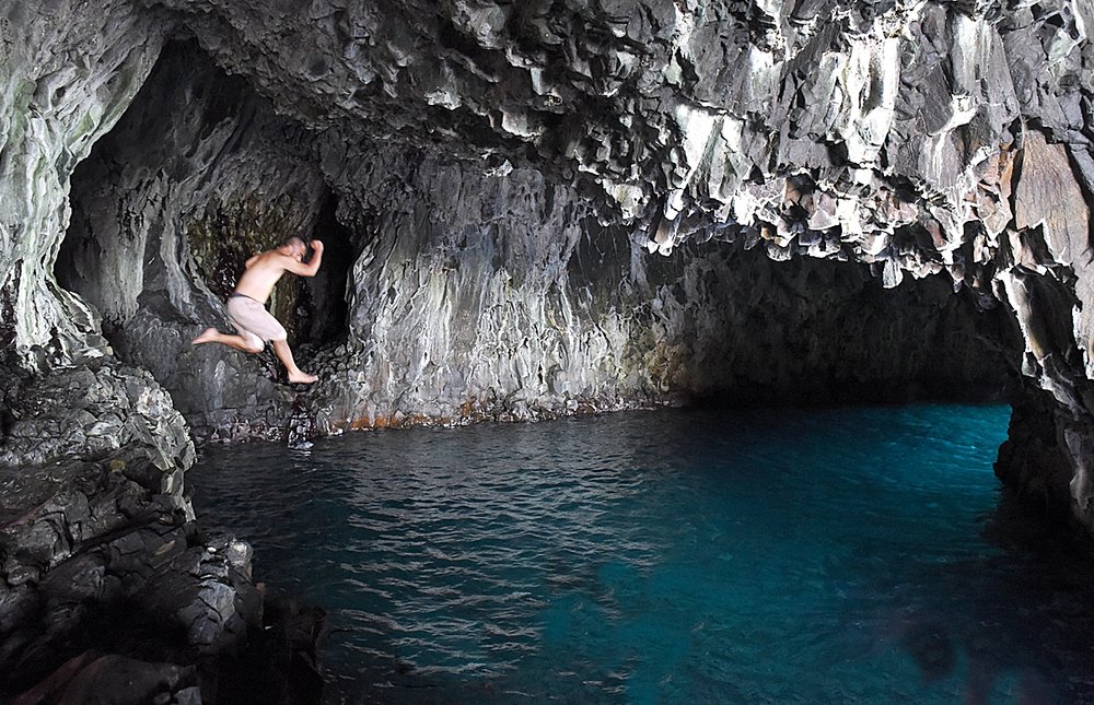 Leap into the cool natural pool found inside Lusok Cave